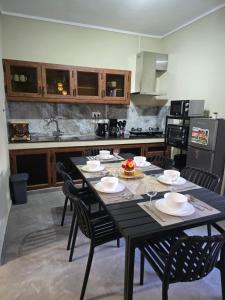 a kitchen with a black table and chairs and a kitchen with a counter at Blue Bay beach Apartment in Blue Bay