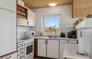 a kitchen with white cabinets and a window at Gorgeous Home In Harboøre With Sauna in Harboør +25 photos