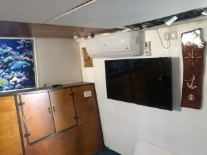 a kitchen with a microwave and a cabinet and a painting at הפנינה הלבנה in Eilat