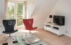 a living room with two chairs and a tv at Three-Bedroom Holiday Home In Blavand in Blåvand