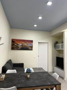 een woonkamer met een tafel en een bank bij 10 min da Navigli e centro, nuova e luminosa oasi 1p in Milaan