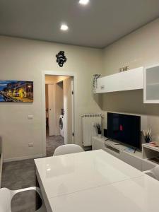 een woonkamer met een witte tafel en een tv bij 10 min da Navigli e centro, nuova e luminosa oasi 1p in Milaan +13 foto's