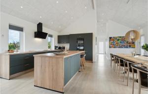 a kitchen with blue cabinets and a bar with stools at Lovely Home In Hadsund With Wifi in Hadsund