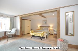 a bedroom with a bed and a table and chairs at Mickleton Hills Farm Cotswold Holiday Cottages in Chipping Campden +53 photos