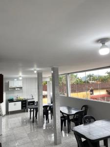 a kitchen and dining room with tables and chairs at Suite 6 a 3 quadras da praia in Bertioga