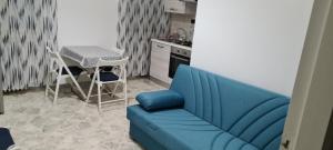 布林迪西Cristal Apartment的带蓝色沙发的客厅和厨房
