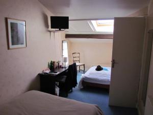 - une chambre avec un bureau et un lit dans l'établissement L'Oustal, à Naves