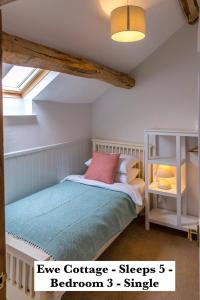 a bedroom with a bed in a attic at Mickleton Hills Farm Cotswold Holiday Cottages in Chipping Campden