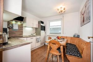 une cuisine avec une table et des chaises dans une pièce dans l'établissement Fewo Trudi, à Waltenhofen