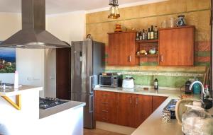 eine Küche mit Holzschränken und einem Edelstahlkühlschrank in der Unterkunft 5 Bedroom Cozy Home In Arenas in Arenas