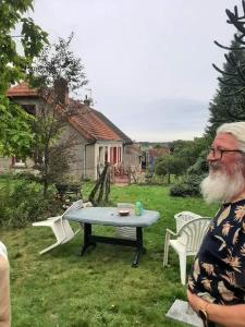 a man standing next to a table in a yard at Espace Spirituel in Saint-Sulpice-le-Dunois