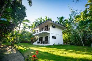 a white house in the middle of a yard at Watergate Villa- Siargao Island in General Luna