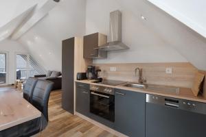 une cuisine avec un évier et une cuisinière four supérieur dans l'établissement Ferienwohnung Maurer, à Königsfeld im Schwarzwald