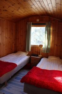 een slaapkamer met 2 bedden en een raam in een hut bij Lilla Sandereds Gård in Loftahammar