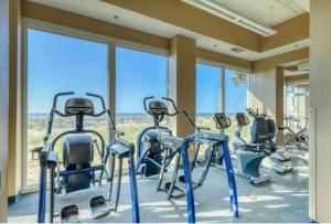 a row of exercise bikes in a gym with windows at Lighthouse 1115 Condo on the beach 3BR 3BA in Gulf Shores