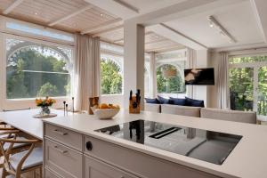 eine Küche mit weißer Arbeitsplatte und ein Wohnzimmer in der Unterkunft Entire Luxury flat with sea view spa pool sauna in Ostseebad Sellin + 21 Fotos