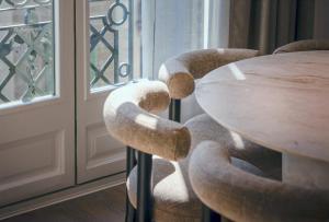 a wooden table with four chairs around it next to a window at The Diagonal Suites by Sweett in Barcelona +19 photos