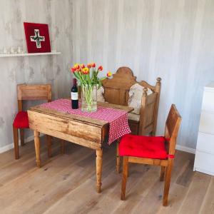 a table with a vase of flowers and a bottle of wine at Kleine Auszeit auf Halbinsel Holnis in Holnis
