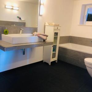 a bathroom with a sink and a toilet and a tub at Kleine Auszeit auf Halbinsel Holnis in Holnis