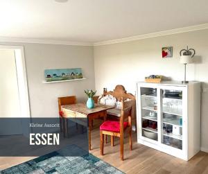 a dining room with a table and a refrigerator at Kleine Auszeit auf Halbinsel Holnis in Holnis