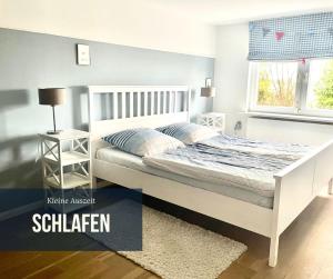 a bedroom with a white bed and a window at Kleine Auszeit auf Halbinsel Holnis in Holnis