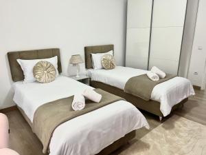 a bedroom with two beds with towels on them at Rainbow Apartments in Floreşti