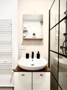 un baño con lavabo y espejo en Rainbow Apartments, en Floreşti 15 fotos más