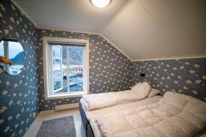 un dormitorio con una cama y una ventana en Svolvær Villa i Lofoten, en Svolvær