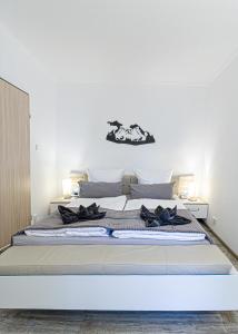 a white bedroom with a large bed with two shoes on it at Ferienwohnung Activities & Relax, Skilift&Downhill in Winterberg