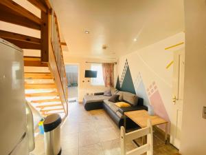 a living room with a couch and a staircase at The Mews Flats - Cambridge, Central Location CB1 in Cambridge