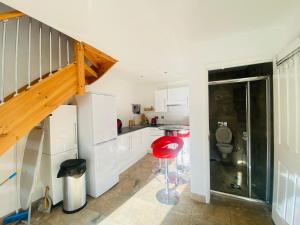 a kitchen with white cabinets and a red stool at The Mews Flats - Cambridge, Central Location CB1 in Cambridge +9 photos