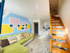 a living room with a green couch and a staircase at The Mews Flats - Cambridge, Central Location CB1 in Cambridge