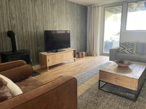 a living room with a couch and a flat screen tv at Sandscape - Eco Beach House - Close to Beach - Pet Friendly in Camber