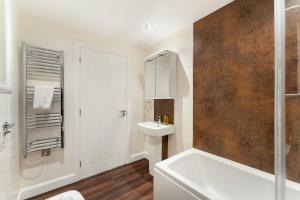 a bathroom with a white tub and a sink at Lakes Cottage in Backbarrow +37 photos