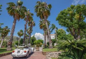 a white car parked in front of palm trees at Villa Irlanda Grand Hotel in Gaeta