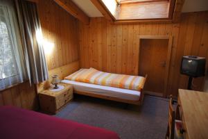 ein kleines Schlafzimmer mit einem Bett und einem Fenster in der Unterkunft Hotel Bellary in Grindelwald