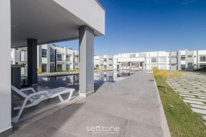 ein Gebäude mit einer Bank und einem Schwimmbecken in der Unterkunft Apartamentos próx. da praia do Mutá/BA - RFMs in Coroa Vermelha + 204 Fotos