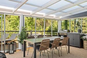 a conservatory with a table and chairs and windows at Stay North - Mustikka in Lohja
