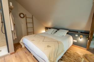a bedroom with a large bed in a attic at Les Secrets de la Baie - le Refuge - parenthèse enchantée avec Spa privatif in Étaples