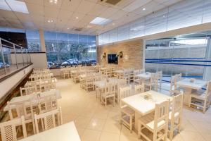 a dining room with white tables and chairs at Hotel San Gabriel in São Paulo