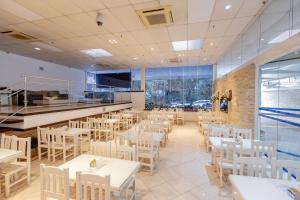 a dining room with white tables and white chairs at Hotel San Gabriel in São Paulo