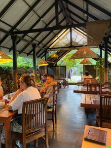 un gruppo di persone sedute ai tavoli di un ristorante di Sigiri Shen Residence a Sigiriya