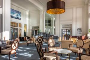 a lobby with chairs and tables and a chandelier at Cavendish Hotel in Eastbourne