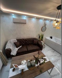 a living room with a brown couch and a table at Teddy Bear Jacuzzi Spa Apartment Sarajevo in Sarajevo