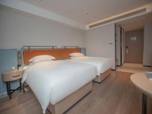 Uma cama ou camas num quarto em Echarm Hotel Qingyuan Qingcheng Station Municipal Government Shop