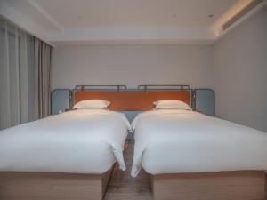 Uma cama ou camas num quarto em Echarm Hotel Qingyuan Qingcheng Station Municipal Government Shop