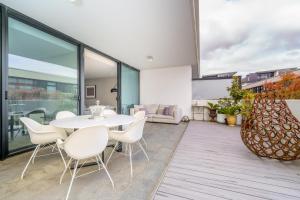 a dining room with a white table and chairs at Elegant Apartment in Kingston Foreshore - Hosted by Canstay in Kingston 