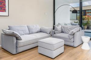 two couches and a stool in a living room at Elegant Apartment in Kingston Foreshore - Hosted by Canstay in Kingston 