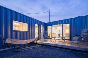 a blue house with a hammock on a deck at Riverside Sauna Base Conpeki in Taniai