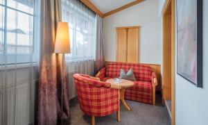salon z czerwoną kanapą i stołem w obiekcie Hotel Königgut w mieście Wals-Siezenheim